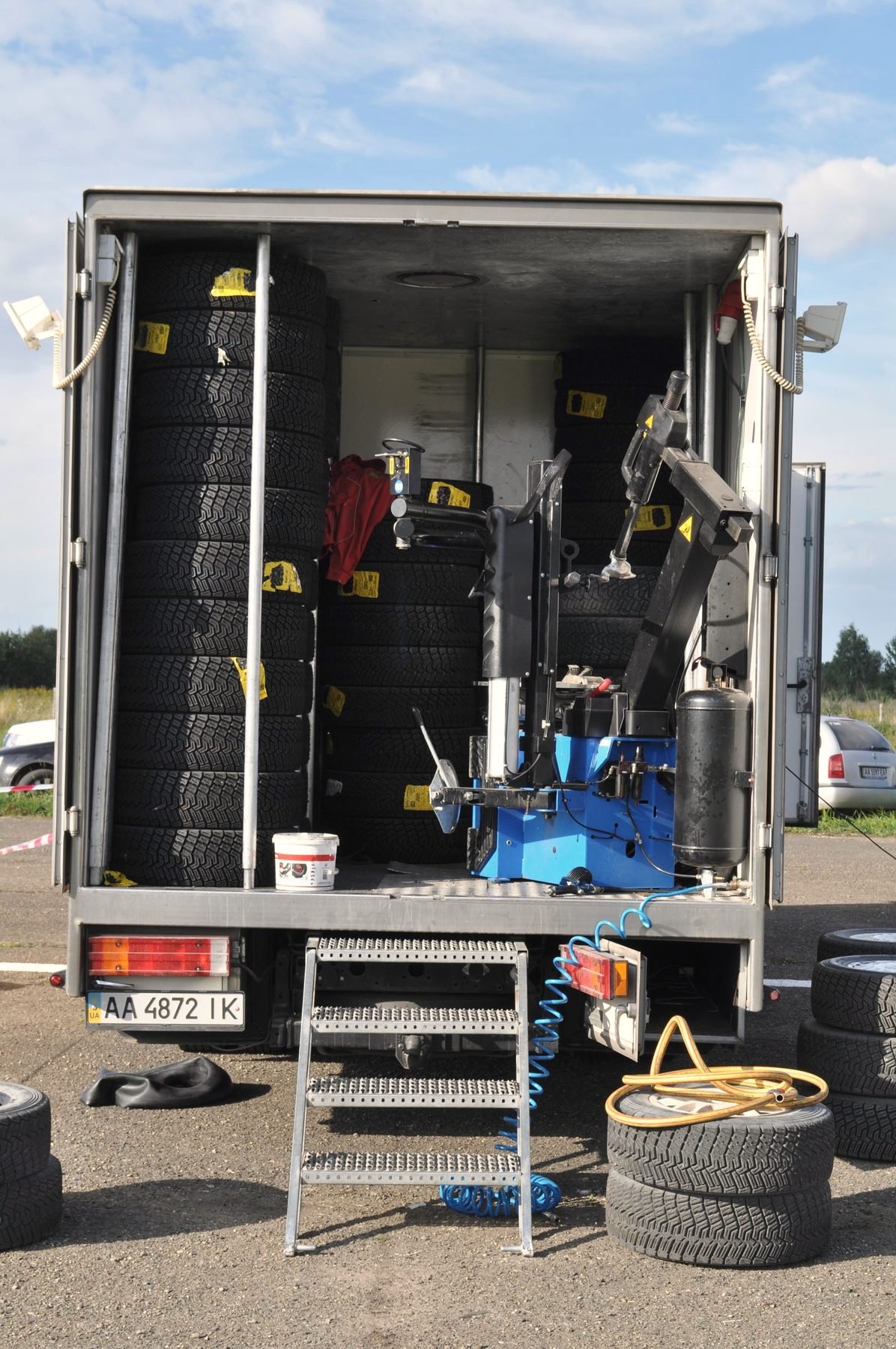 A service truck parked with its rear equipment bay open at the roadside