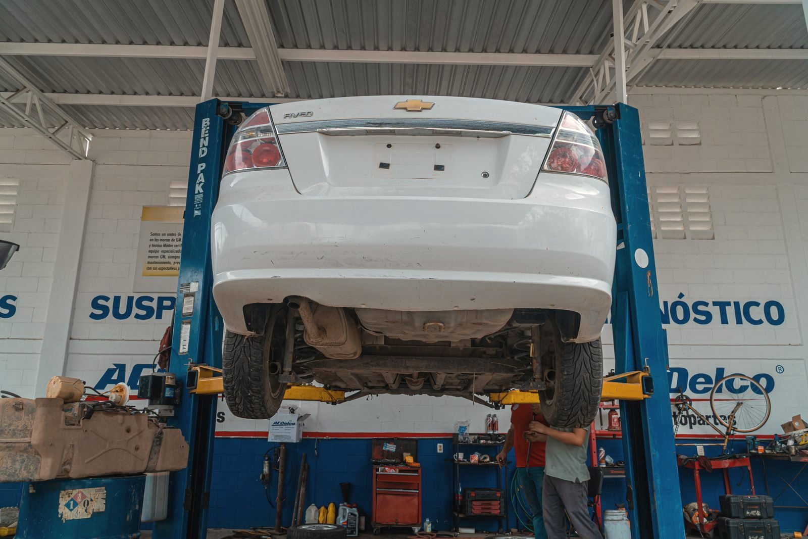 A vehicle raised on a two-post lift in the repair bay